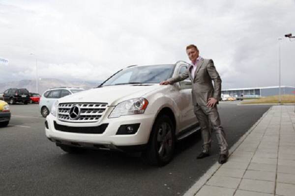 Гисласон позира до един от внесените в Исландия конвертирани електрически Mercedes ML